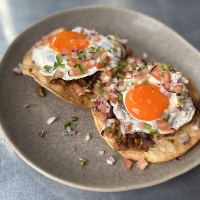 Tostadas topped with fried eggs and pico de gallo at Hash House