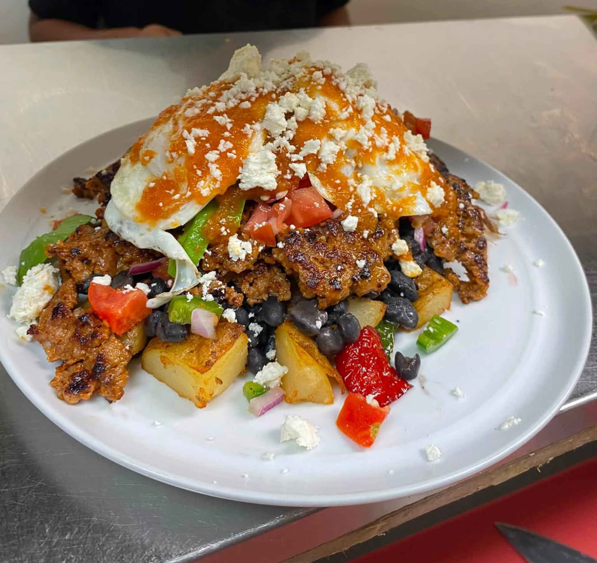 Skillet hash with fried egg, black beans, potatoes and crumbled chorizo-style meat at Hash House