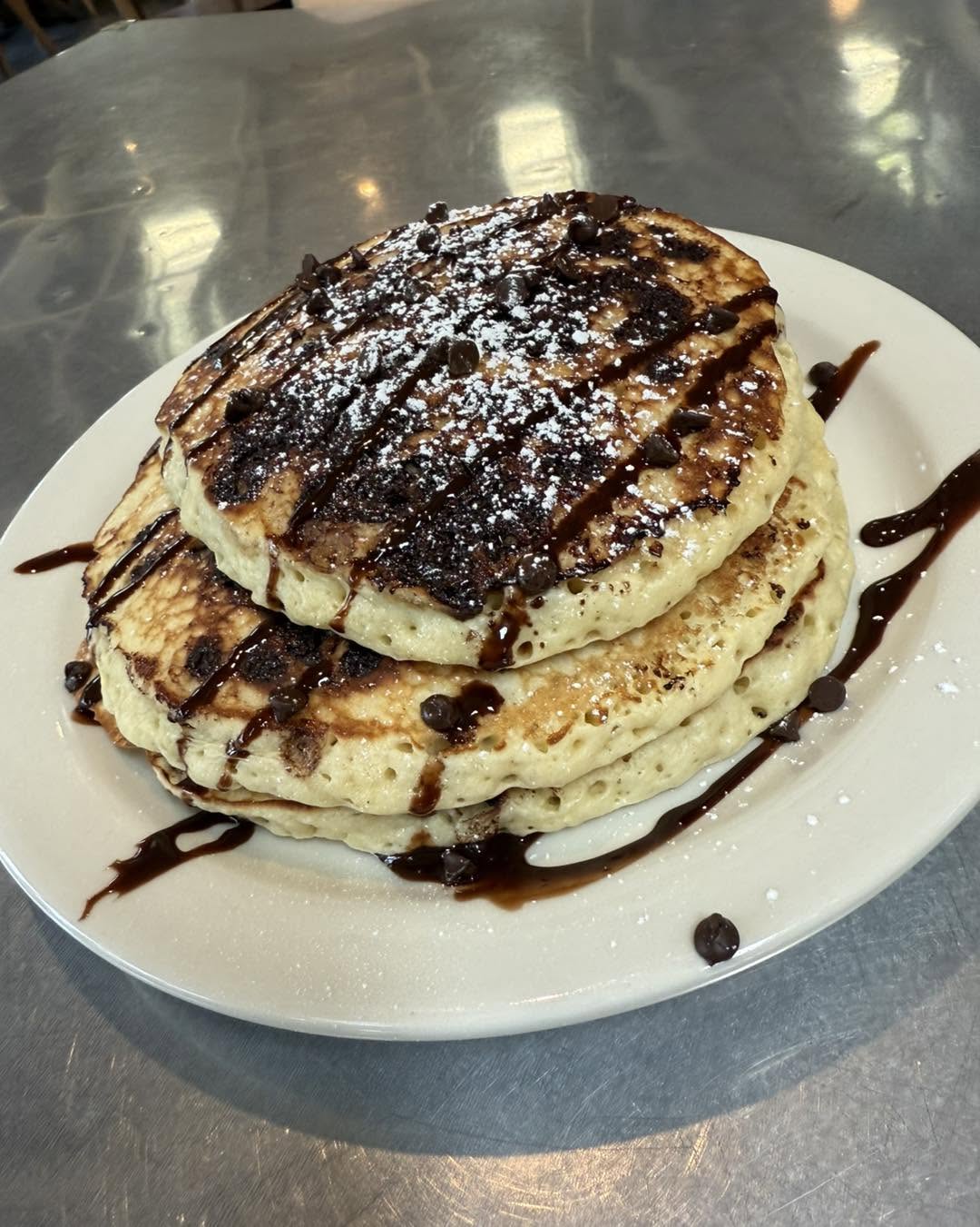 Stack of chocolate chip pancakes with chocolate drizzle at Hash House