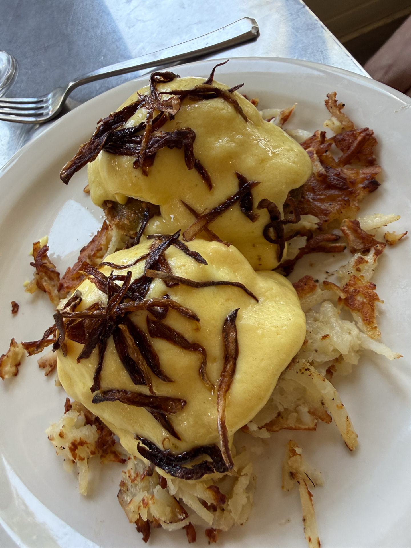 Avocado eggs Benedict with crispy hash browns and fried onions at Hash House