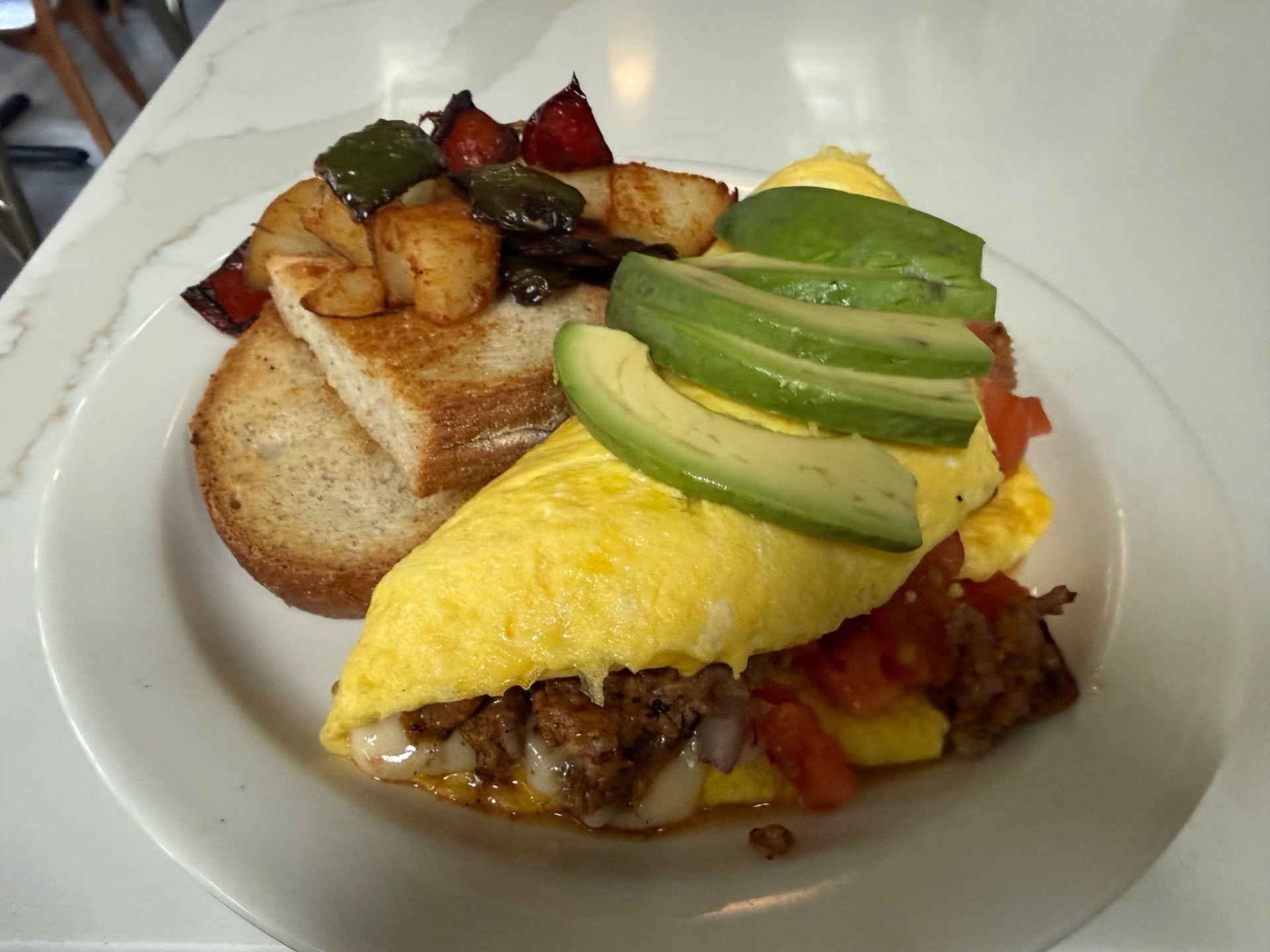 Omelette with avocado, toast and breakfast potatoes at Hash House